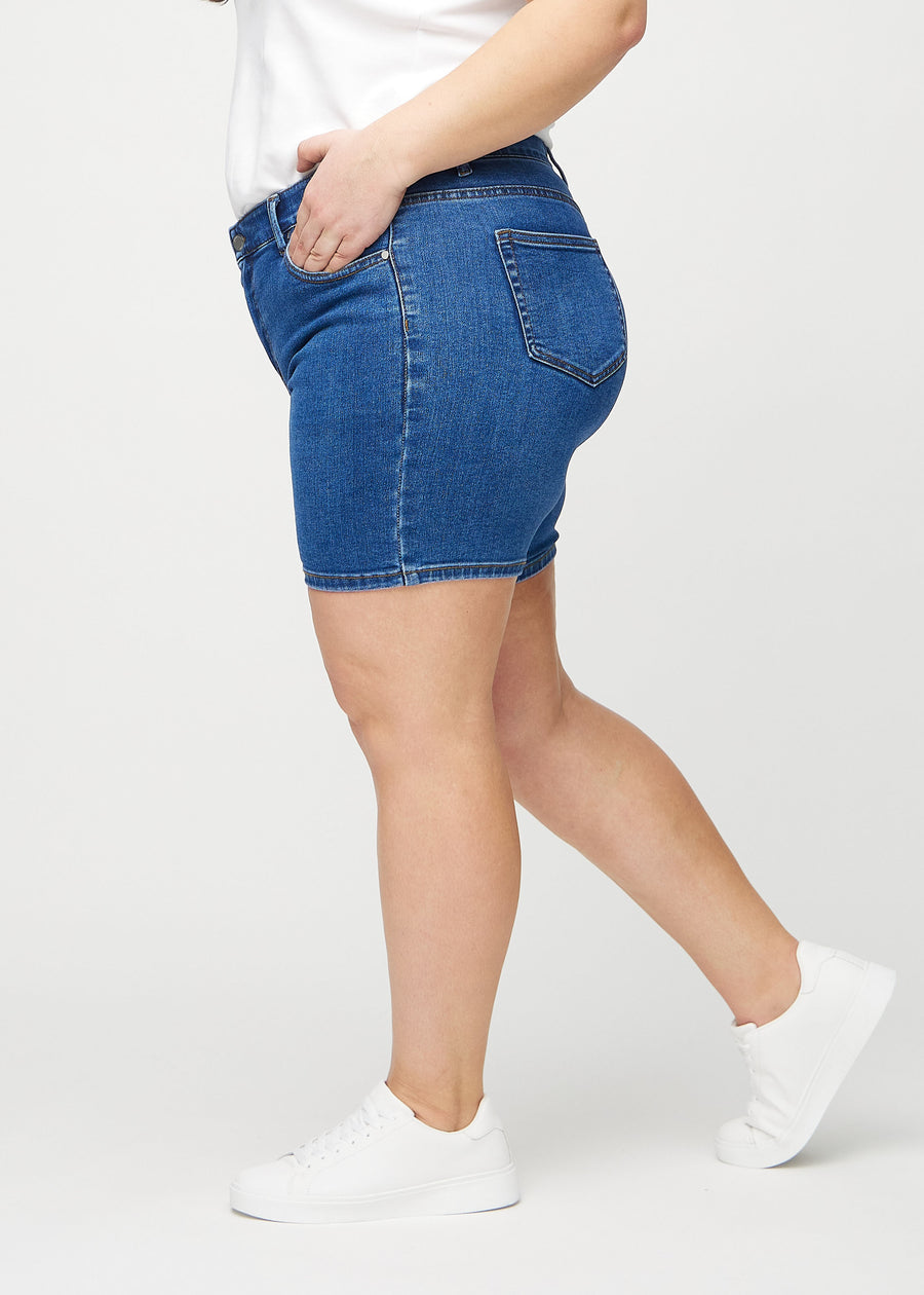 Dunkle Denim-skinny Short Shorts seitlich an einem Plus-Size-Model gesehen.
