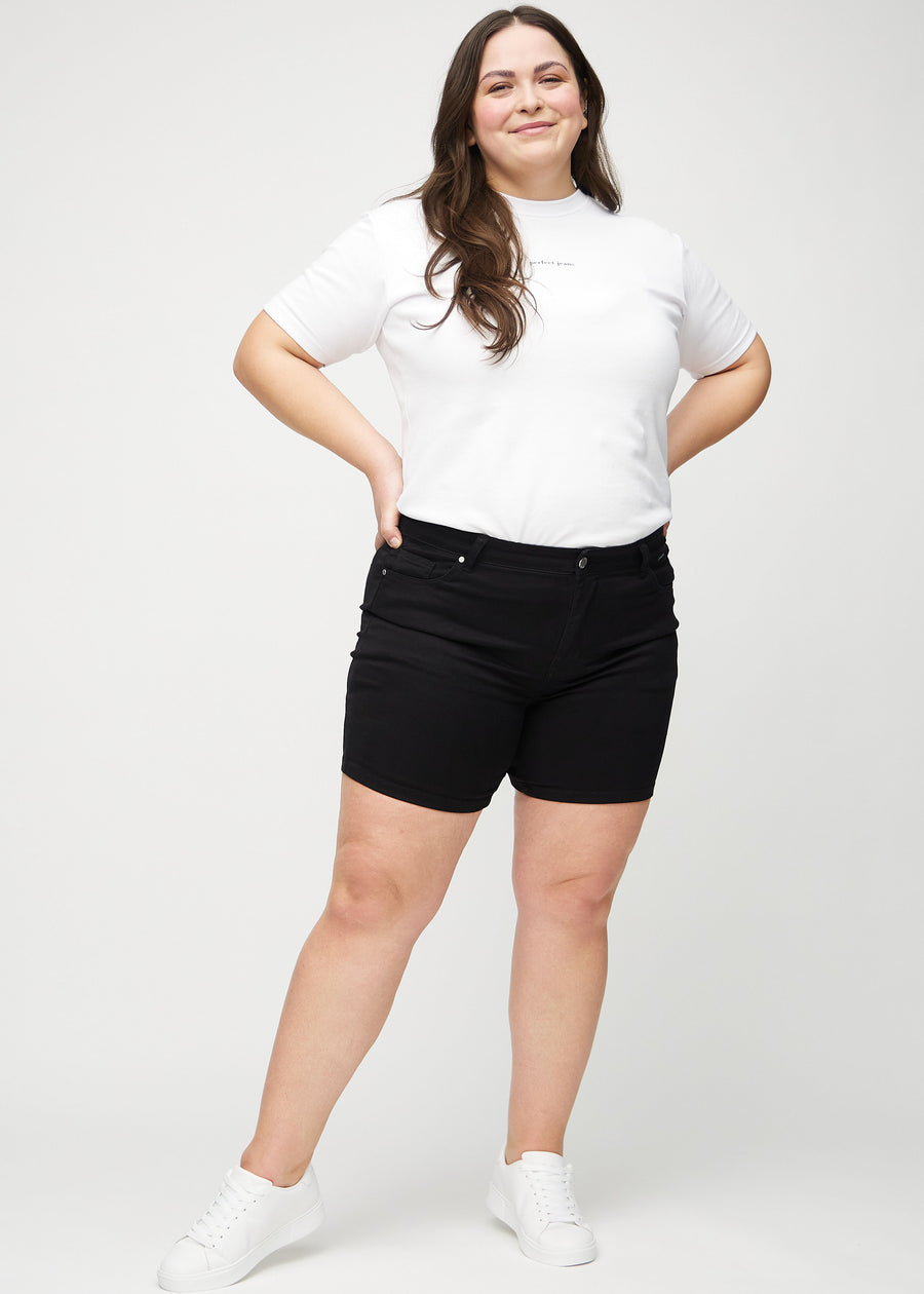 Ganzkörperbild eines Plus-Size-Models in schwarzen skinny Short Shorts.