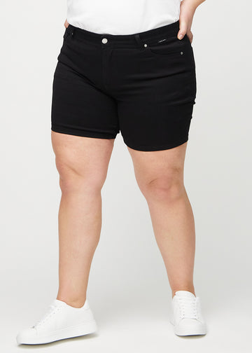 Schwarze skinny Short Shorts, Modellname Ravens, die eng anliegen und bei einem Plus-Size-Model bis zur Mitte des Oberschenkels reichen, von vorn gesehen.