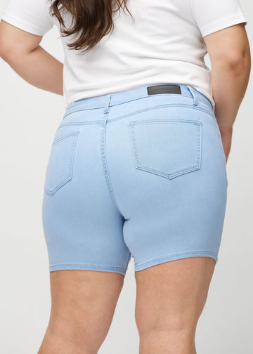  Hellblaue skinny short shorts von hinten in Nahaufnahme an einem Plus-Size-Model, um Details zu zeigen.