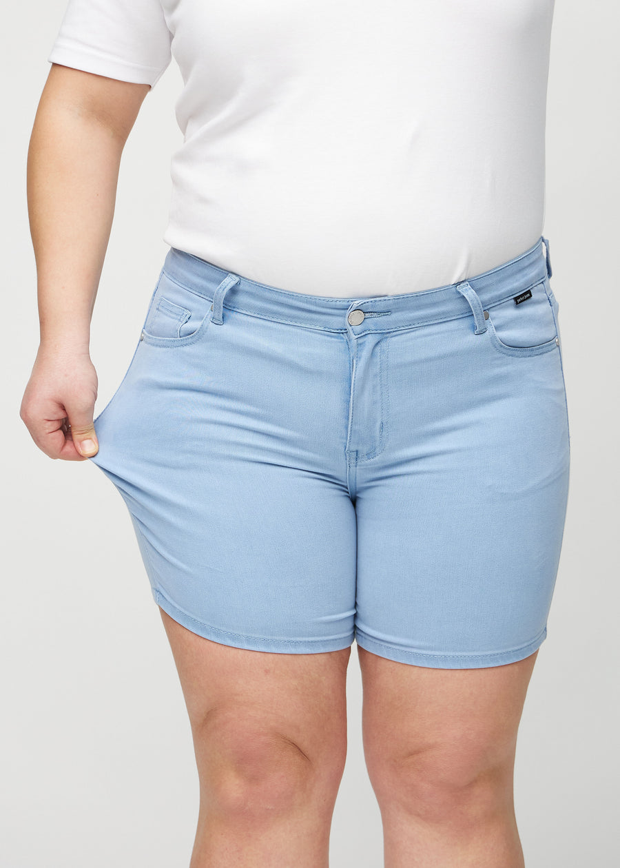 Das Plus-Size-Model zieht die Shorts am Oberschenkel, um den Stretch zu zeigen.