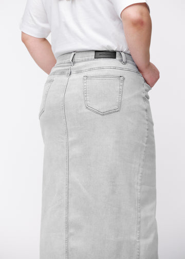 Langer hellgrauer Denimrock für Damen in der Farbe Ashes. Nahaufnahme der Rückseite an einem Plus-Size-Model, um Passform und Details zu zeigen.