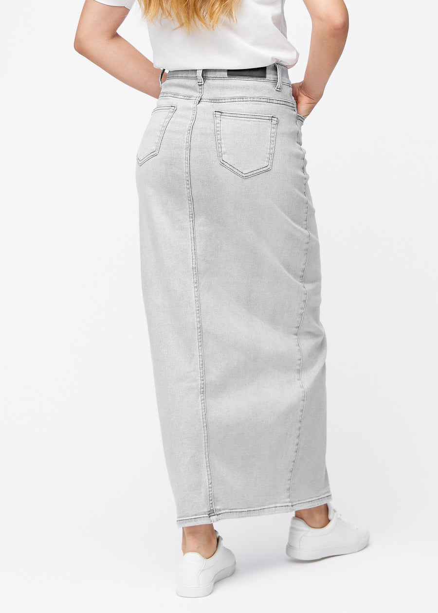 Langer hellgrauer Denimrock für Damen in der Farbe Ashes. Rückansicht an einem Model, die volle Länge des Rocks ist zu sehen.