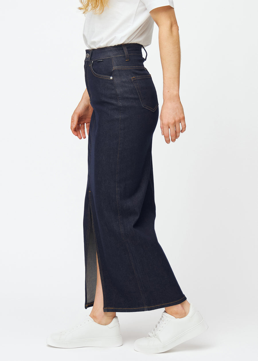 Langer tief dunkelblauer Denim-Rock für Damen in der Farbe Midnights, von der Seite am Model gesehen, mit sichtbarem Schlitz vorne.