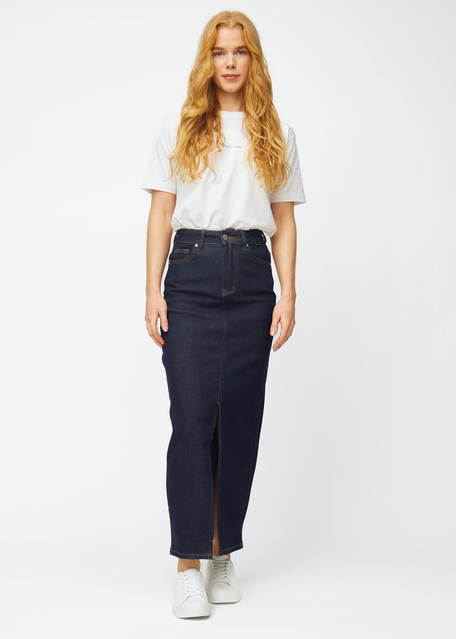Ganzkörperbild eines Models in einem langen tief dunkelblauen Denim-Rock für Damen in der Farbe Midnights mit Schlitz vorne.