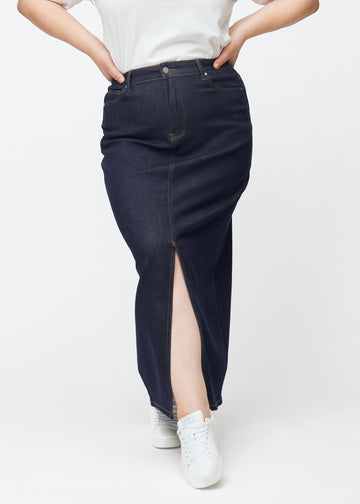 Langer tief dunkelblauer Denim-Rock für Damen in der Farbe Midnights von vorne auf einem Plus-Size-Model gesehen, mit Schlitz vorne, der knapp unter dem Knie beginnt.