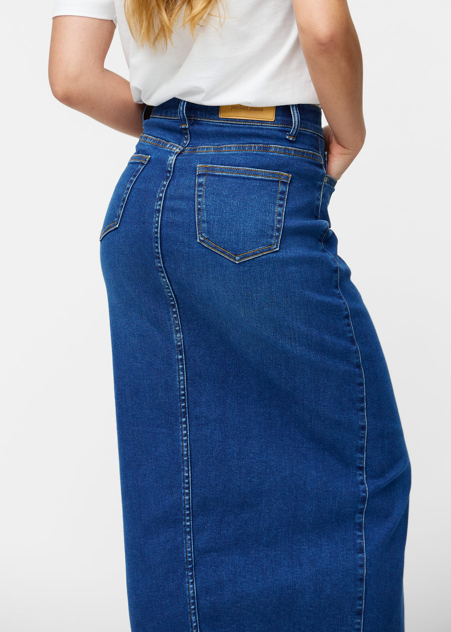 Lang, mørkeblå denimnederdel i farven Oceans set bagfra tæt på for at vise pasform og detaljer.
