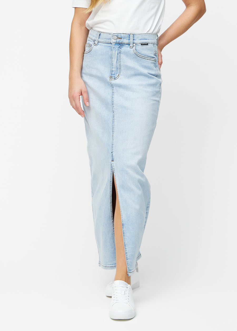 Lang, lyseblå denimnederdel i farven Waves med regulær pasform, der sidder tæt til hoften og falder lige ned til anklerne, med slids foran der starter lige under knæet, set forfra.