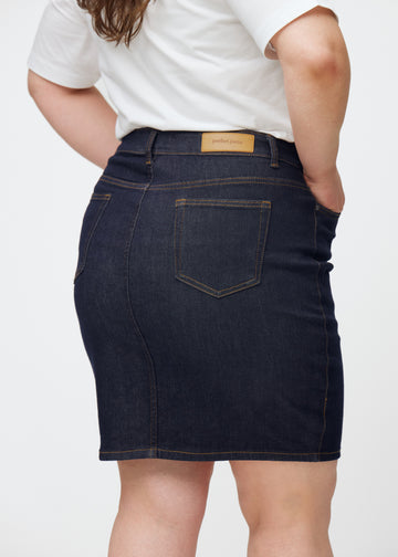 Tief dunkelblaue Denim-Rock für Damen in der Farbe Midnights von hinten nah auf einem Plus-Size-Model aufgenommen.