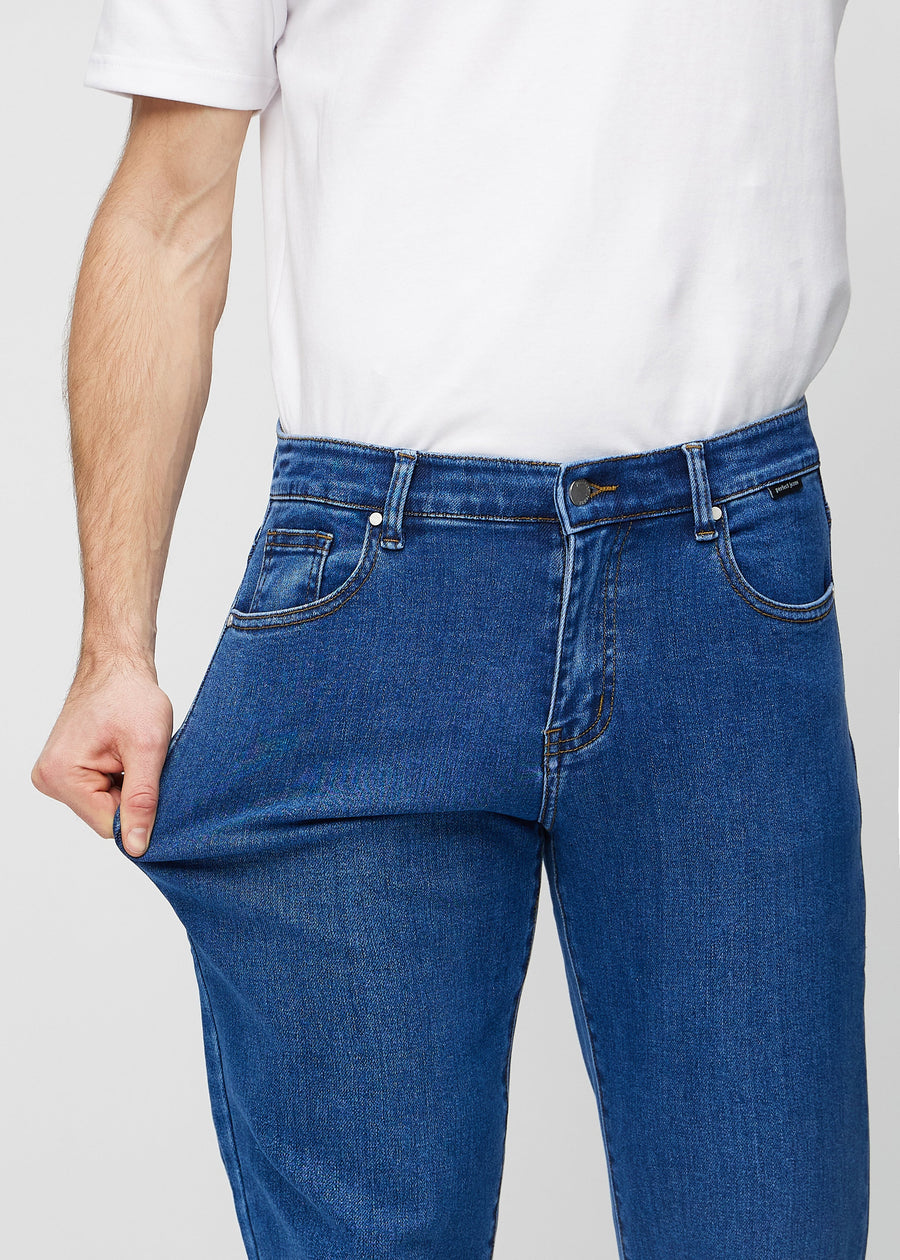 Das Model dehnt die Jeans am Oberschenkel, um den Stretch zu zeigen.