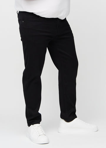 Schwarze regular jeans, Modellname Ravens, die gerade am Bein herunterfallen, an einem Plus-Size-Model von vorne gesehen.