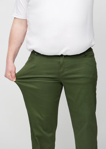 Das Plus-Size-Model zieht die Jeans am Oberschenkel auseinander, um den Stretch zu zeigen.