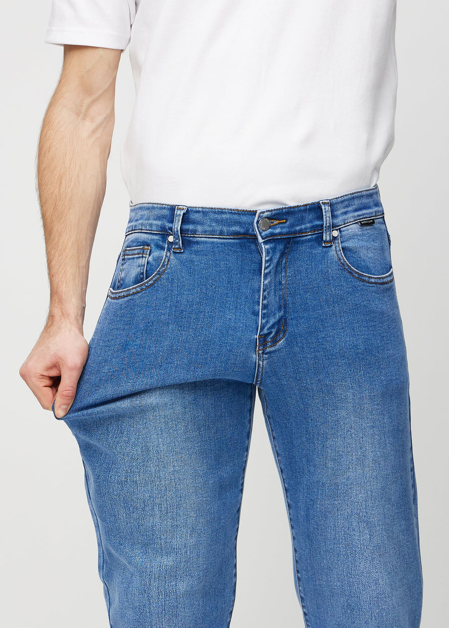 Das Model dehnt die Jeans am Oberschenkel, um den Stretch zu zeigen.