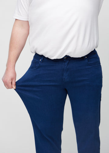 Das Plus-Size-Model zieht die Jeans am Oberschenkel auseinander, um den Stretch zu zeigen.