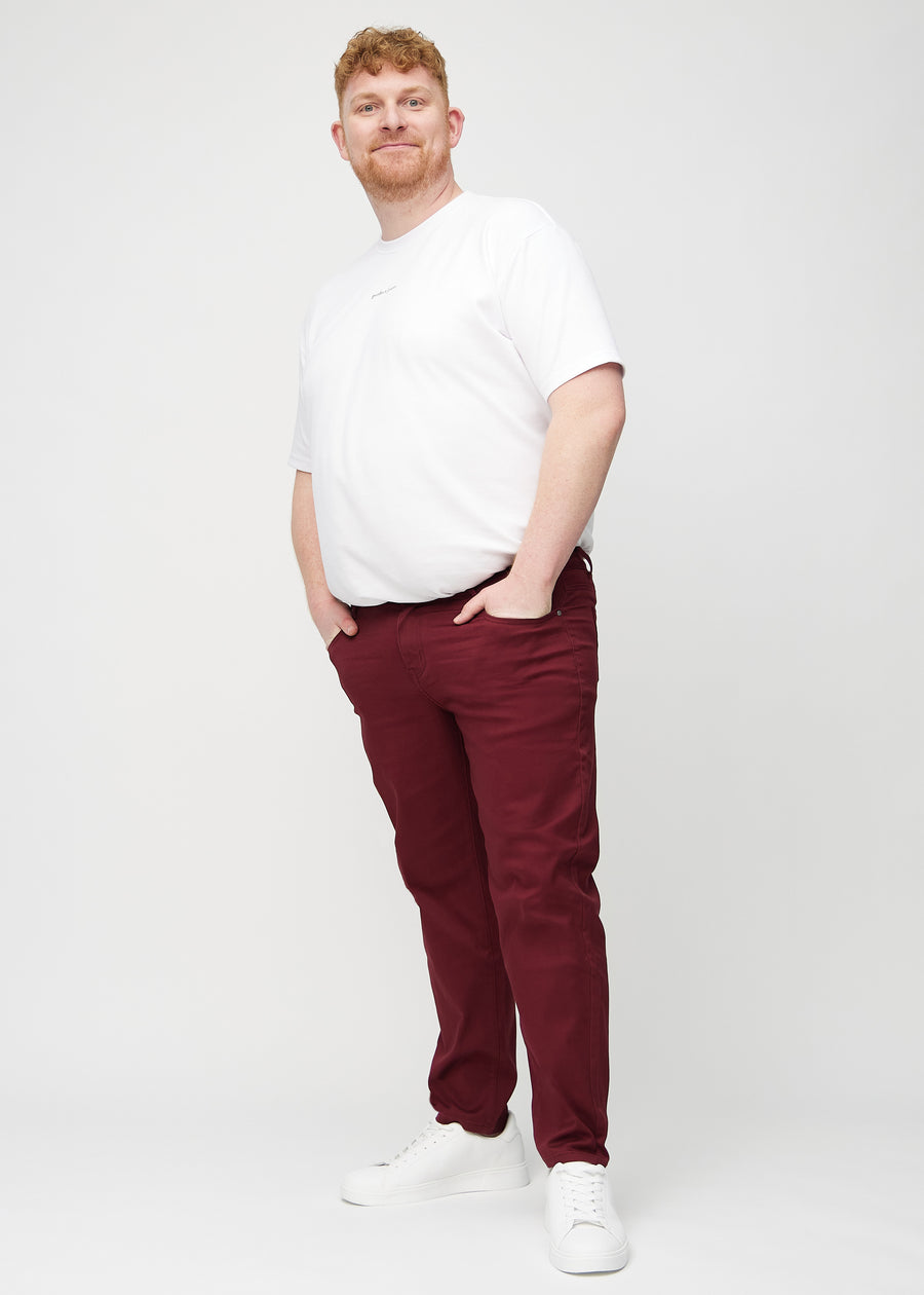 Ganzkörperbild eines Plus-Size-Models in dunkelroten regular jeans.