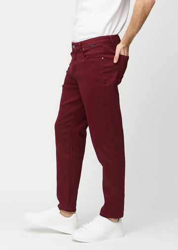 Dunkelrote regular jeans, seitlich am Model gesehen.