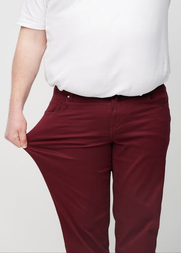 Ein Plus-Size-Model dehnt die Jeans am Oberschenkel, um den Stretch zu zeigen.