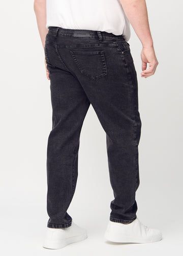 Dunkelgrauer Denim regular jeans von hinten an einem Plus-Size-Model gezeigt, sodass man das gesamte Produkt sehen kann.