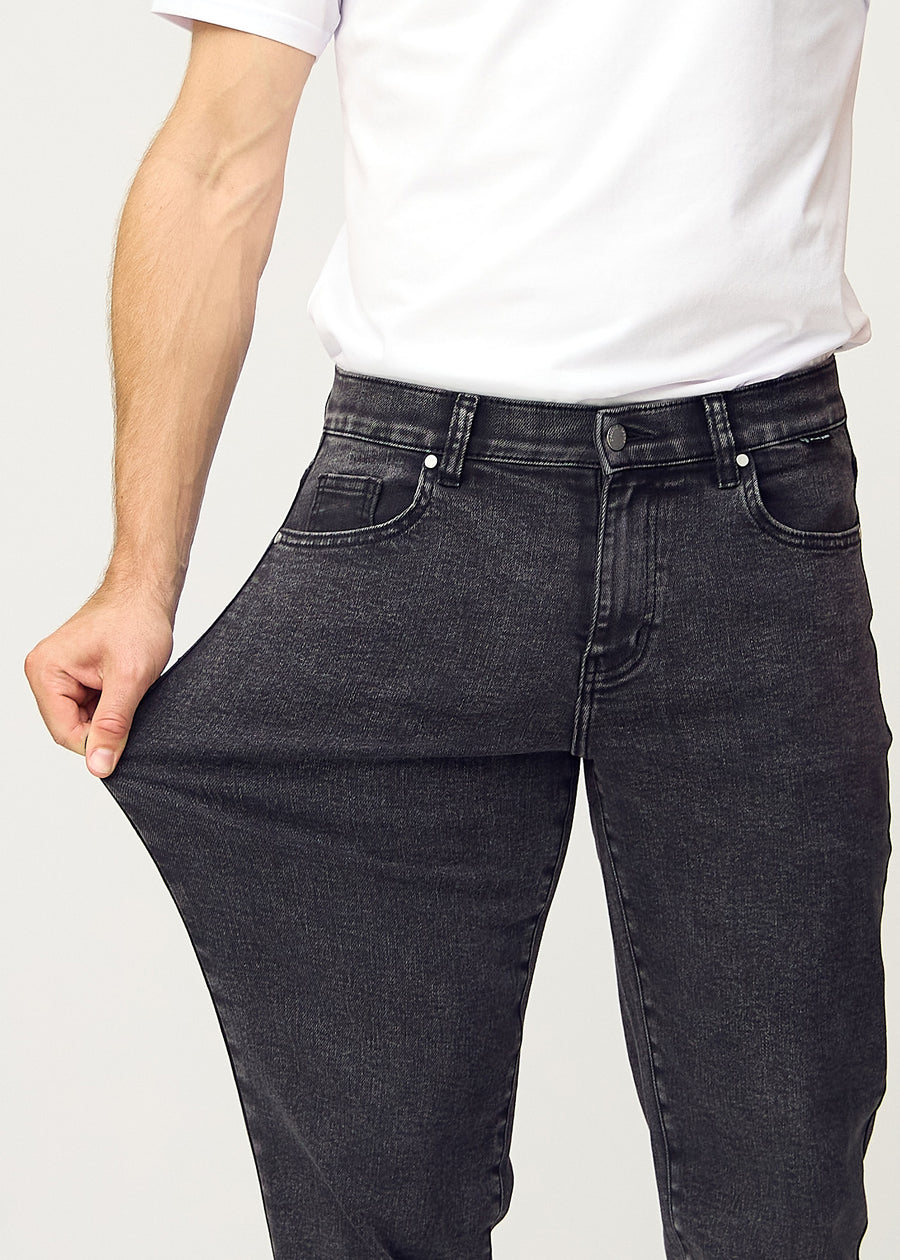 Das Model zieht die Jeans am Oberschenkel auseinander, um den Stretch zu zeigen.