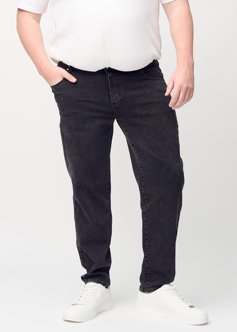 Dunkelgrauer Denim regular jeans, Modellname Shadows, der am Bein gerade nach unten verläuft, an einem Plus-Size-Model von vorne gezeigt.
