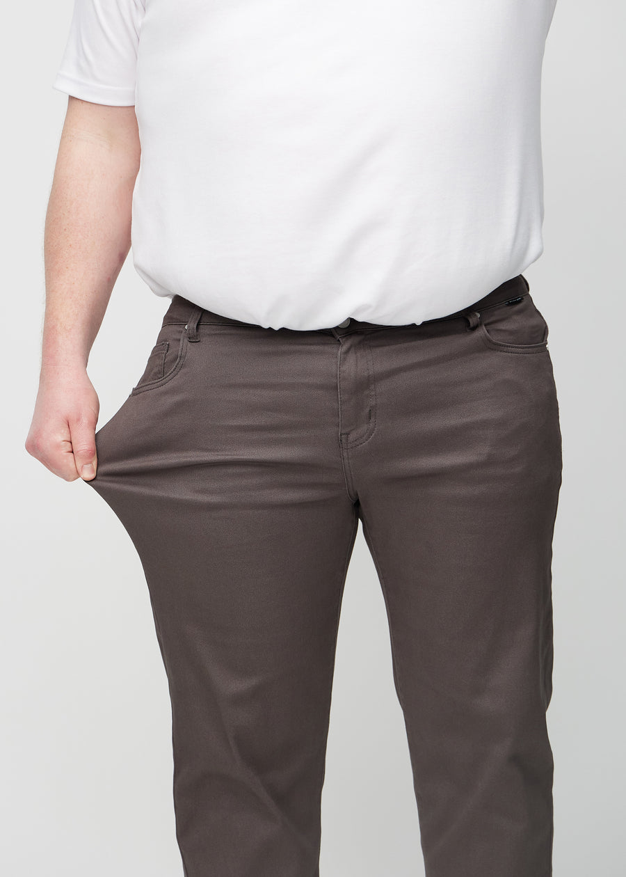 Das Plus-Size-Model dehnt die Jeans am Oberschenkel, um den Stretch zu zeigen.
