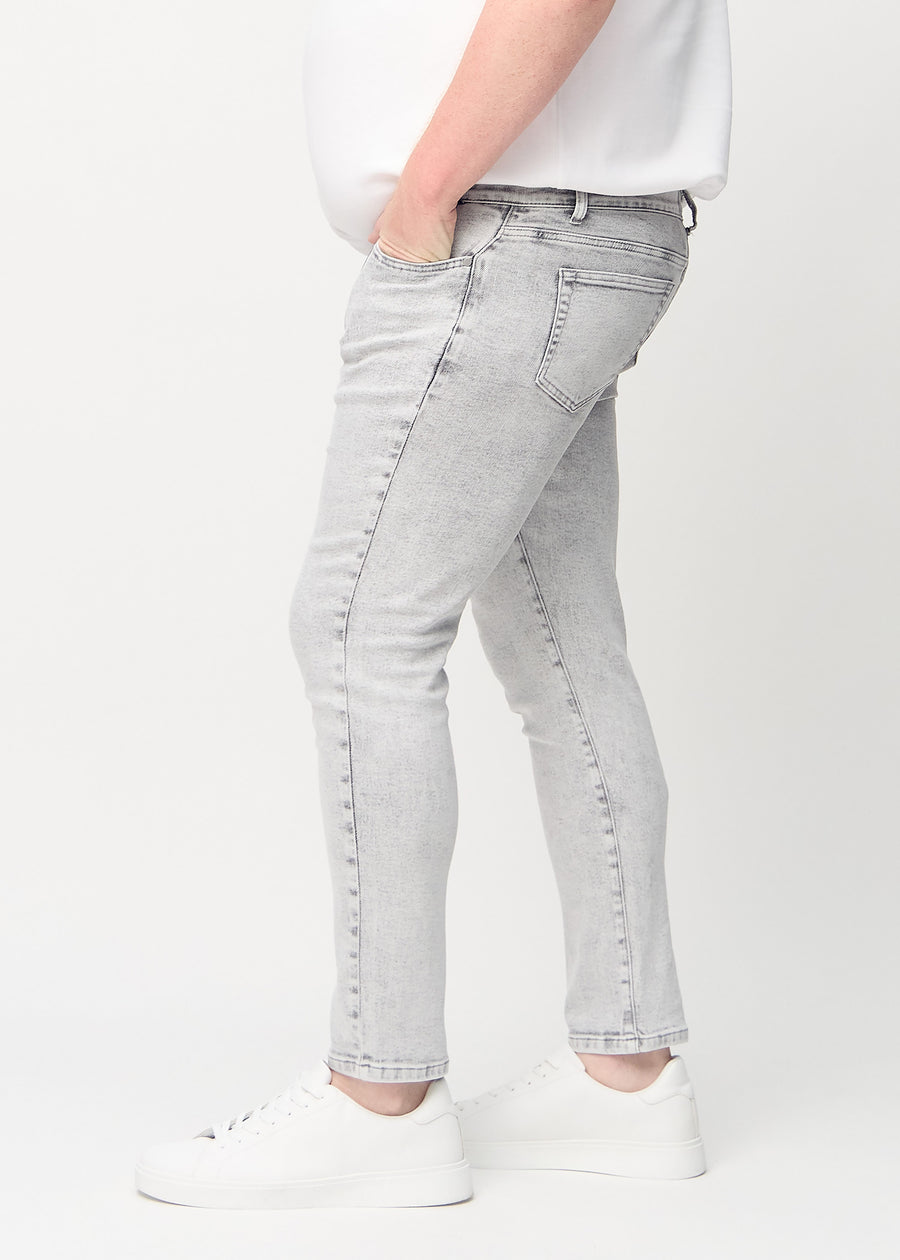 Hellgraue Denim-Jeans im Slim Fit, von der Seite an einem Plus-Size-Model gesehen.