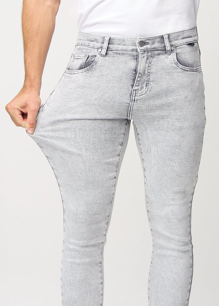 Ein Model dehnt die Jeans am Oberschenkel, um den Stretch des Materials zu zeigen.