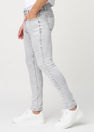 Hellgraue Denim-Jeans im Slim Fit, von der Seite an einem Model gesehen.