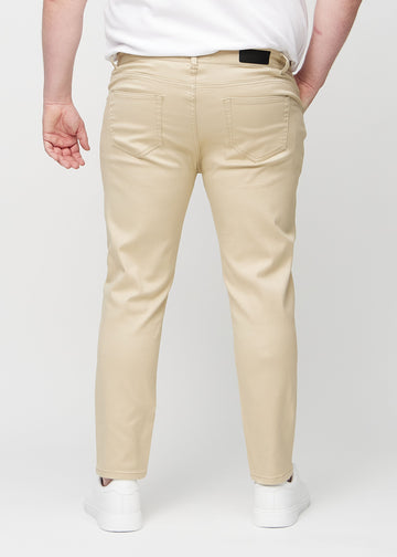 Beigefarbene Jeans im Slim Fit, von hinten an einem Plus-Size-Model gesehen, um die gesamte Jeans zu zeigen.
