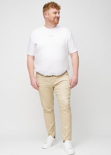 Ganzkörperaufnahme eines Plus-Size-Models in beigefarbene Jeans im Slim Fit.