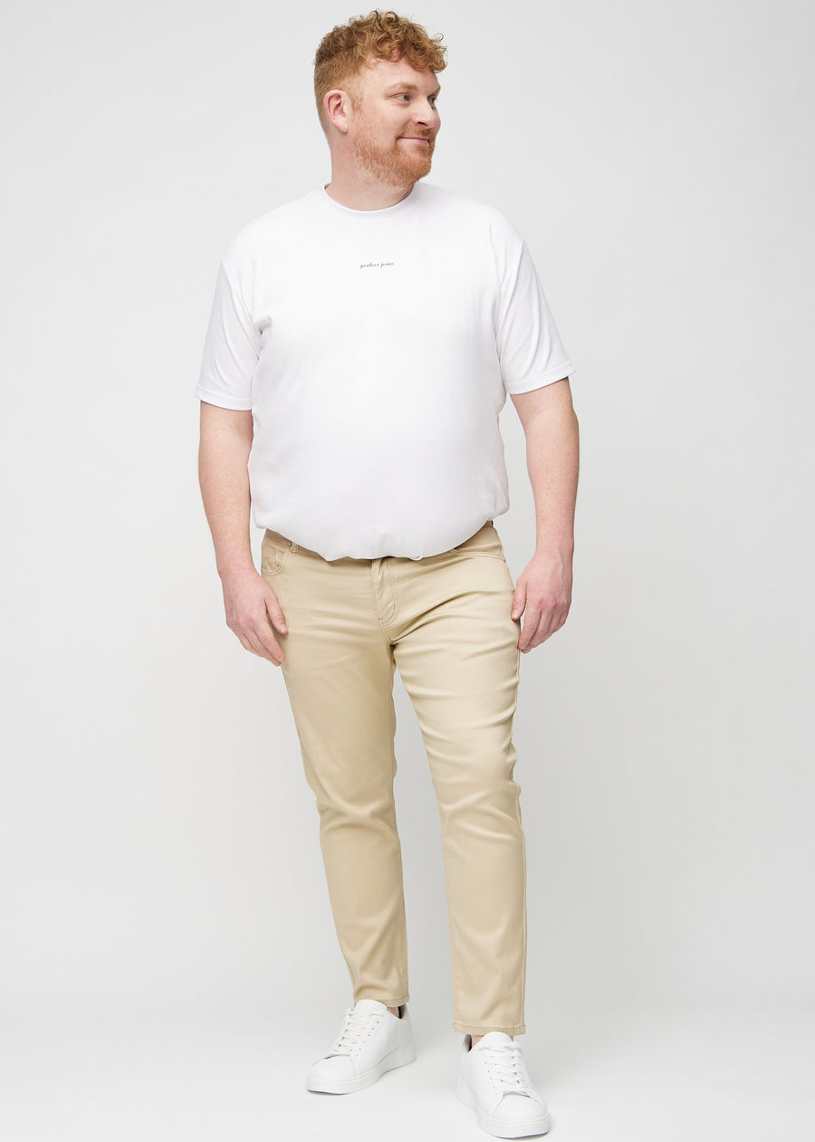 Ganzkörperaufnahme eines Plus-Size-Models in beigefarbene Jeans im Slim Fit.