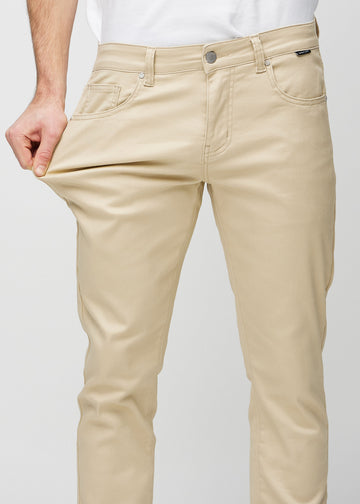 Ein Model dehnt die Jeans am Oberschenkel, um den Stretch des Materials zu zeigen.