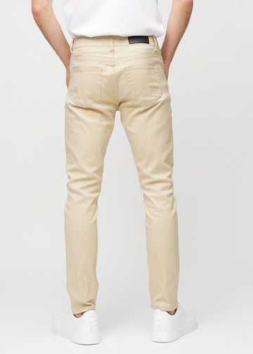 Beigefarbene Jeans im Slim Fit, von hinten gesehen, um die gesamte Jeans zu zeigen.