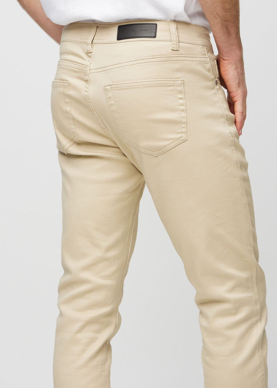Nahaufnahme von hinten von beigefarbene Jeans im Slim Fit, die Details zeigt.