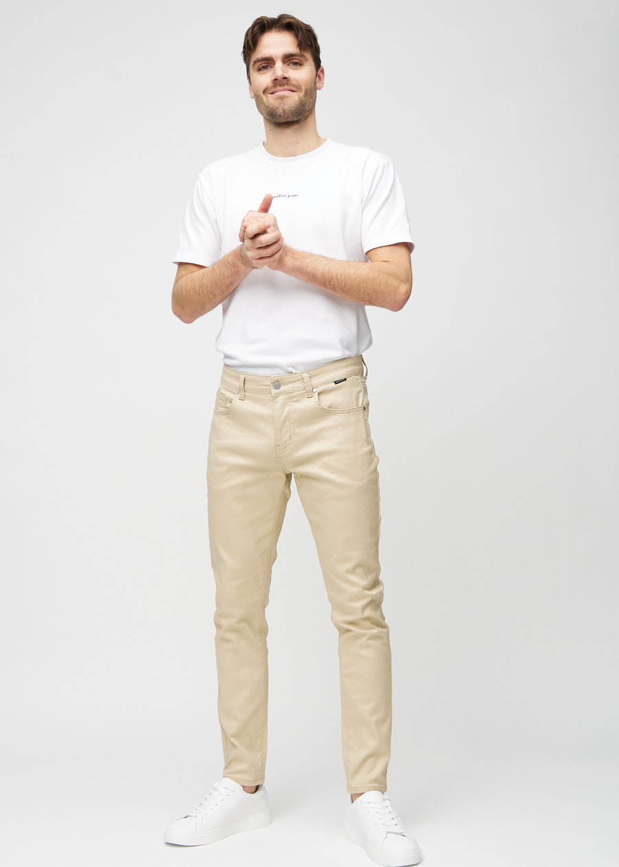 Ganzkörperaufnahme eines Models in beigefarbene Jeans im Slim Fit.