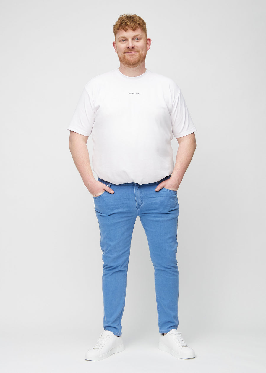 Ganzkörperaufnahme eines Plus-Size-Models in blaue Jeans im Slim Fit.