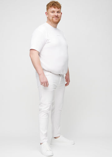 Ganzkörperaufnahme eines Plus-Size-Models in weiße Jeans im Slim Fit.