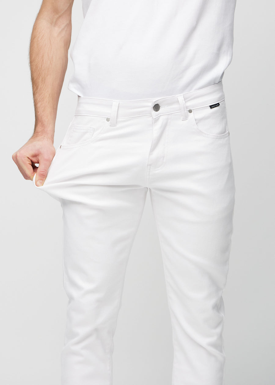 Ein Model dehnt die Jeans am Oberschenkel, um den Stretch des Materials zu zeigen.