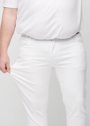 Ein Plus-Size-Model dehnt die Jeans am Oberschenkel, um den Stretch des Materials zu zeigen.