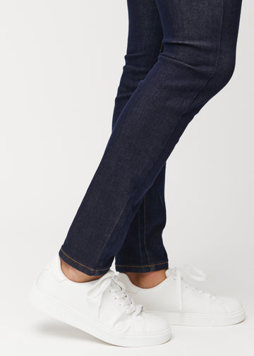 Nahaufnahme der Knöchelpartie von tief dunkelblauen Midnights Denim-Jeans für Herren im Slim Fit, die den schmalen Beinabschluss zeigt.