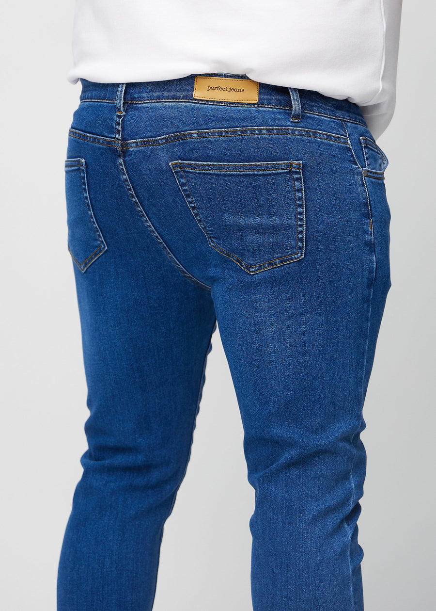 Nahaufnahme von hinten von dunkelblaue Denim-Jeans im Slim Fit an einem Plus-Size-Model, die Details zeigt.
