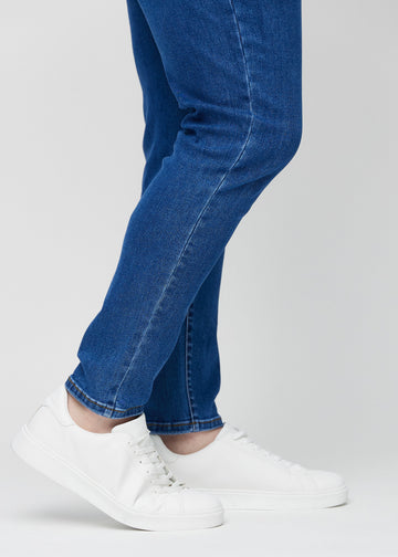 Knöchelbereich eines Plus-Size-Models, der zeigt, wie eng die Jeans anliegen.