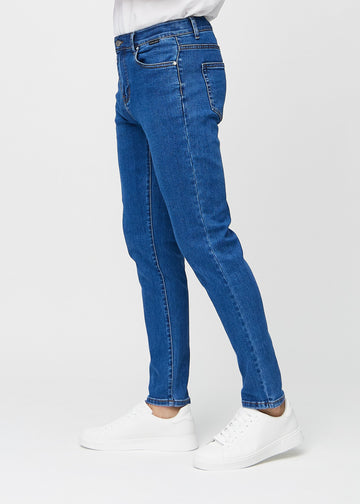 Dunkelblaue Denim-Jeans im Slim Fit, von der Seite an einem Model gesehen.