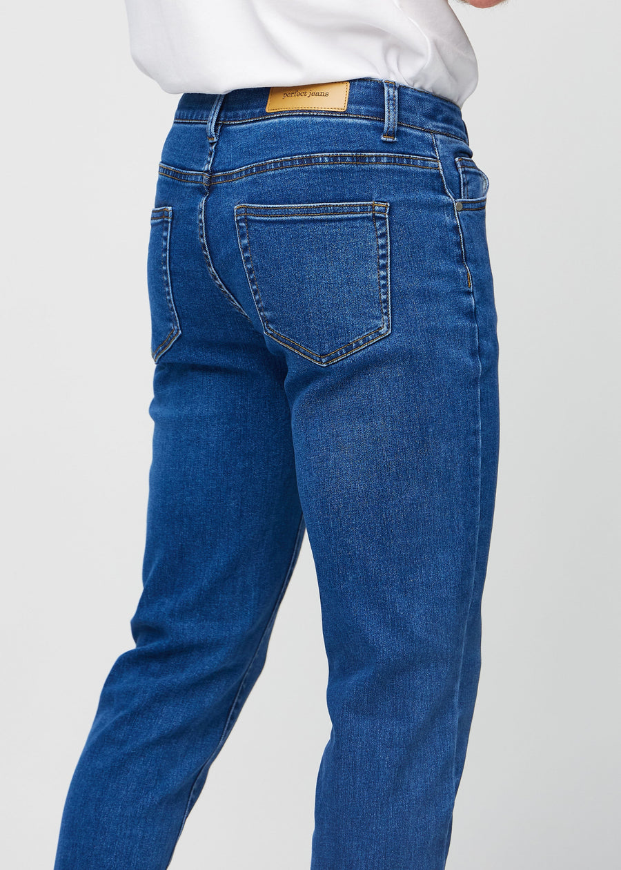 Nahaufnahme von hinten von dunkelblaue Denim-Jeans im Slim Fit, die Details zeigt.