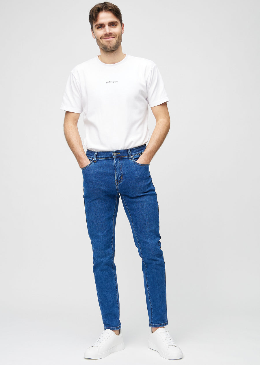 Ganzkörperaufnahme eines Models in dunkelblaue Denim-Jeans im Slim Fit.
