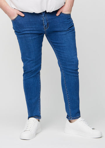 Dunkelblaue Denim-Jeans im Slim Fit, Modell Oceans, die an einem Plus-Size-Model eng an den Beinen anliegen, von vorne gesehen.