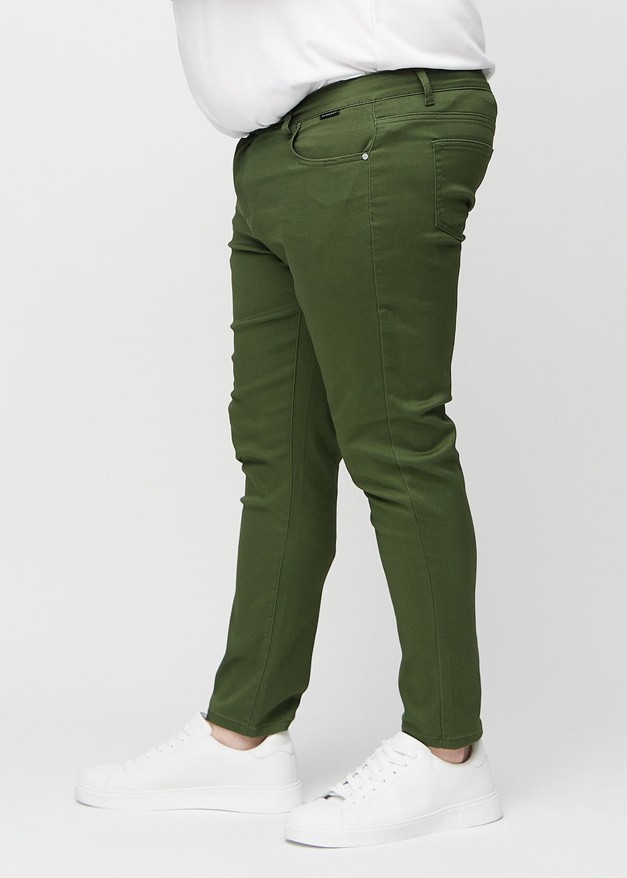 Dunkelgrüne Jeans im Slim Fit, von der Seite an einem Plus-Size-Model gesehen.
