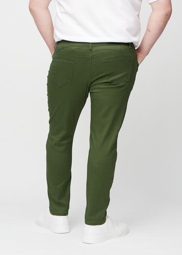 Dunkelgrüne Jeans im Slim Fit, von hinten an einem Plus-Size-Model gesehen, um die gesamte Jeans zu zeigen.