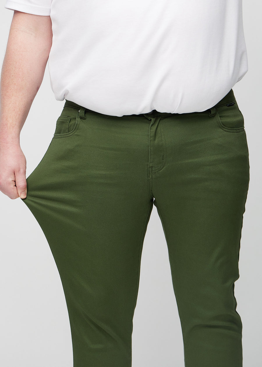 Ein Plus-Size-Model dehnt die Jeans am Oberschenkel, um den Stretch des Materials zu zeigen.