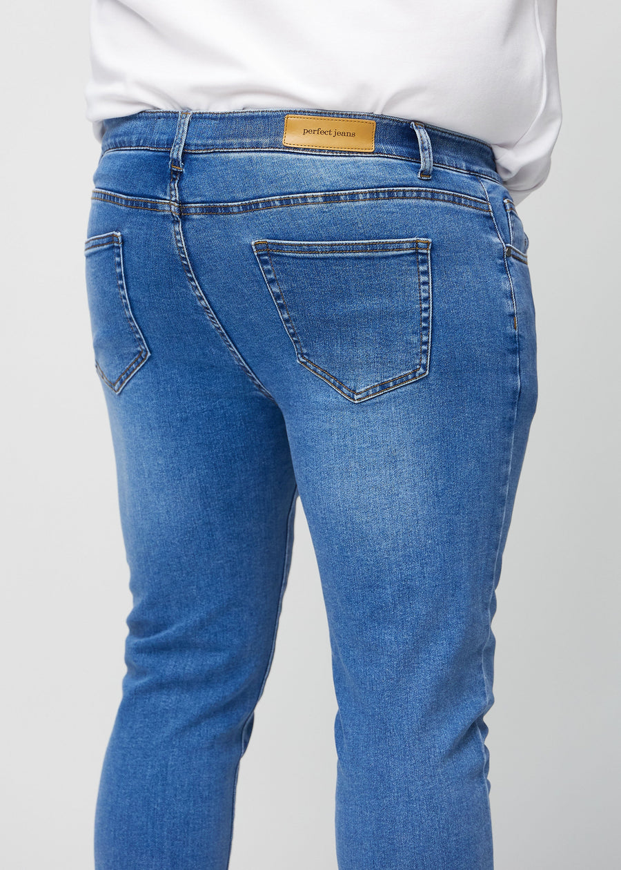 Nahaufnahme von hinten von blaue Denim-Jeans im Slim Fit an einem Plus-Size-Model, die Details zeigt.